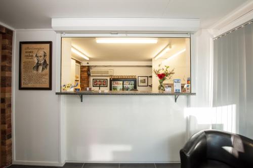 a mirror on a wall in a living room at Allan Cunningham Motel in Toowoomba