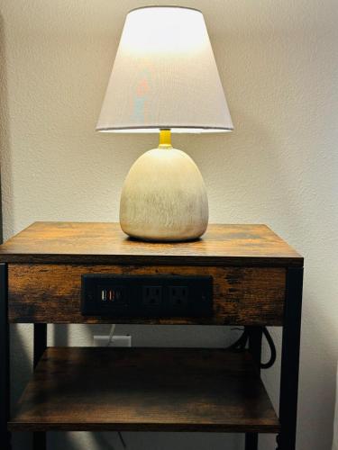 a lamp sitting on top of a table with a clock at Bradshaw Sunset RV Park N Apartment Springtown TX in Springtown