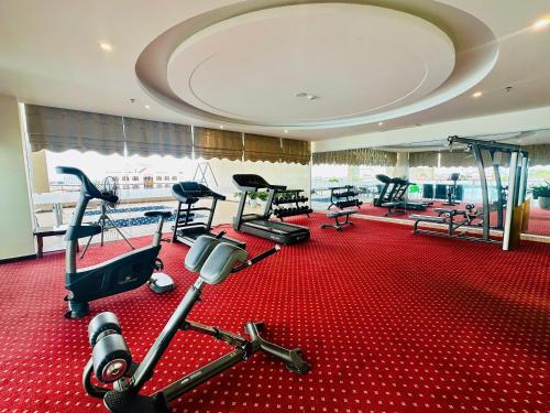a gym with several treadmills and machines in a room at Muong Thanh Grand Quang Tri Hotel in Quang Tri