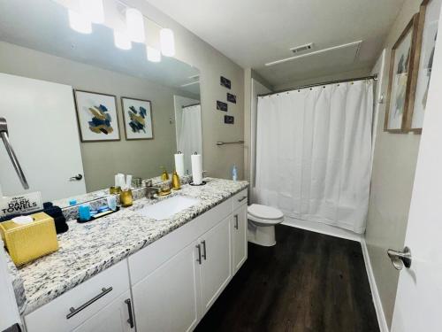 a white bathroom with a sink and a toilet at Great Location Heart of Addison in N Dallas! in Addison