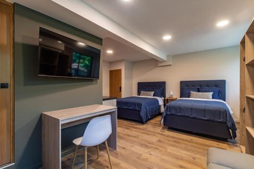 a room with two beds and a flat screen tv at Lora Loca Inn in El Zonte
