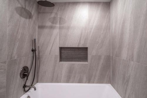 a bathroom with a shower with a tub at New Listing Renovated 2 BR Aspen Condo in Aspen