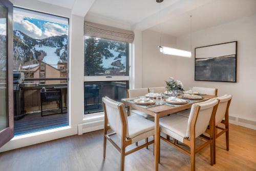 a dining room with a table and chairs and a large window at New Listing Renovated 2 BR Aspen Condo in Aspen