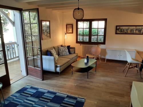 un salon avec un canapé et une table dans l'établissement Maison spacieuse proche du lac d'Hossegor avec jardin, terrasse ensoleillée et studio indépendant - FR-1-239-690, à Soorts-Hossegor