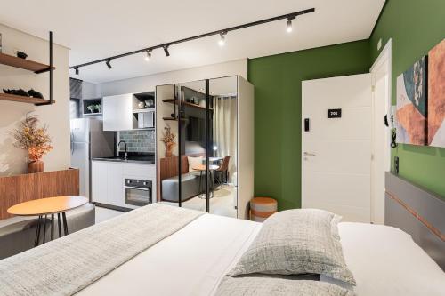 a bedroom with a white bed and a green wall at Luxo e Conforto na Melhor Localização do Centro in Curitiba