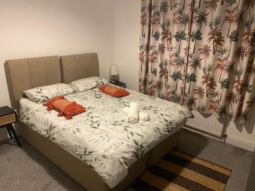 un letto con cuscini arancioni e una candela sopra di Warrington Guest House a Stoke on Trent