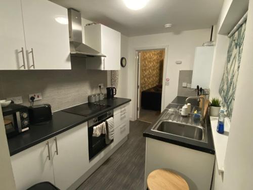 a kitchen with a sink and a counter top at Warrington Guest House in Stoke on Trent