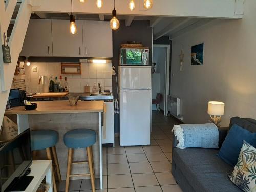 Il comprend une cuisine et un salon avec un réfrigérateur blanc. dans l'établissement Charmante Villa Patio avec Terrasse : Proche Plages et Centre, Idéale pour 4 Personnes - FR-1-239-789, à Capbreton