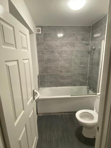 a bathroom with a tub and a toilet and a shower at Warrington Guest House in Stoke on Trent