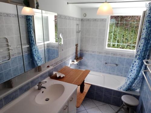 une salle de bain avec une baignoire et un lavabo et une baignoire dans l'établissement Maison de charme avec jardin, 9 couchages, Capbreton - FR-1-239-1035, à Capbreton