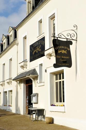 un bâtiment blanc avec un panneau indiquant un restaurant dans l'établissement Le Lion d'Or - Logis Hotels - Hotel 2 étoiles et restaurant, à Ingrandes