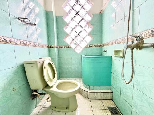 a bathroom with a toilet and a shower at Yani Guesthouse in Bukittinggi