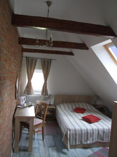 a bedroom with a bed and a table in a attic at Blue House in Braşov
