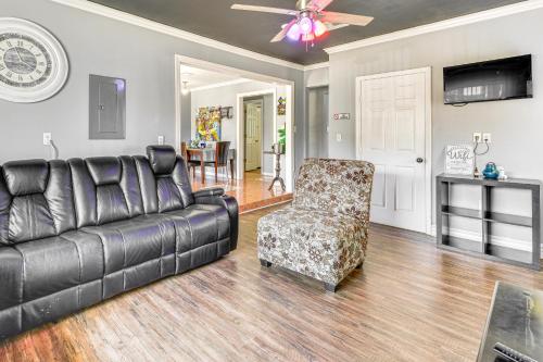 a living room with a leather couch and a chair at 5 Mi to French Quarter NOLA Getaway with Patio! in New Orleans