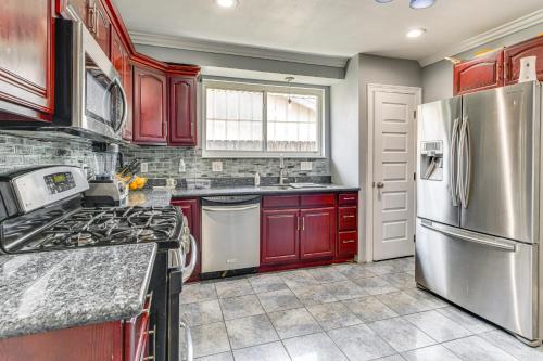a kitchen with red cabinets and stainless steel appliances at 5 Mi to French Quarter NOLA Getaway with Patio! in New Orleans