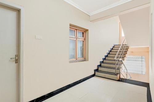 a white room with a staircase and a window at Super Collection O Bhanugudi Junction Kakinada Formerly Stay Inn Luxury in Kākināda