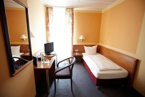 a small hotel room with a bed and a desk at BSW Ferienhotel Lindenbach in Bad Ems