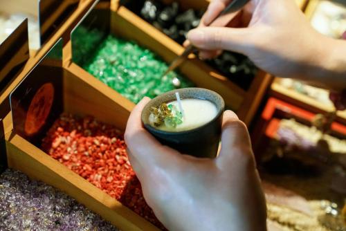 a person holding a drink in a cup in a box at 青城山坐忘森林疗愈酒店 in Dujiangyan