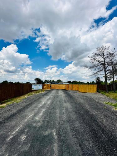 an empty road with a fence and a blue sky at High Noon Hideout Tiny Home in Springtown TX in Springtown