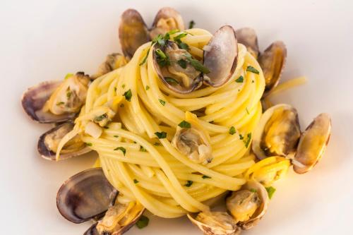 a plate of pasta with clams and mushrooms at Apollon Club & Thermal Spa in Ischia