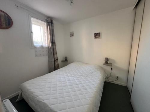 une petite chambre avec un lit blanc et une fenêtre dans l'établissement Le Barcarès T2 en RDC, 4 Pers, Accès Direct Plage, Animaux OK - FR-1-799-55, au Barcarès