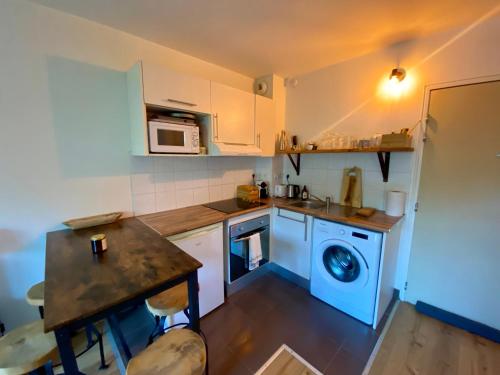 une petite cuisine avec un lave-linge et une table dans l'établissement Formiguères - Appartement T2 Lumineux avec Terrasse, 3 Pers, Proche Pistes et Commerces - FR-1-758-29, à Formiguères