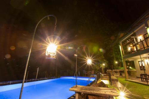 a swimming pool at night with lights at Huluganga Ridge, Kandy in Kandy