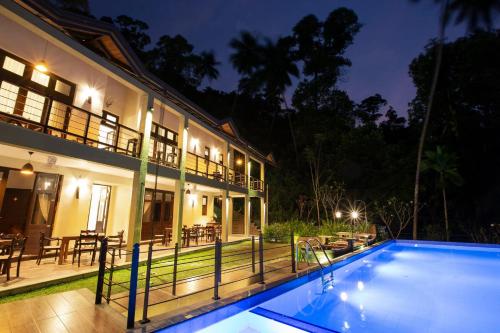 a villa with a swimming pool at night at Huluganga Ridge, Kandy in Kandy