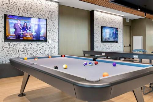 a pool table in a room with a tv at North End 2BR Condo w Pool & Gym in Boston