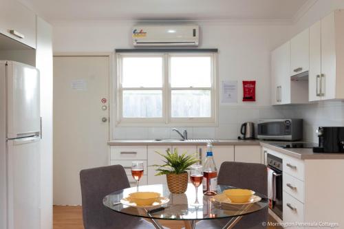 a kitchen with a table and two glasses of wine at MP Beach Club in Tootgarook
