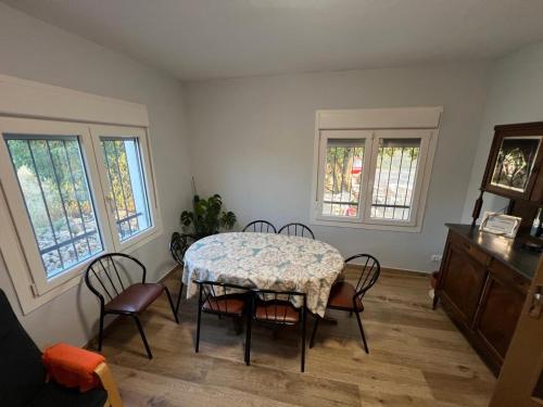 a dining room with a table and chairs and windows at Casa Chao in Estopiñán