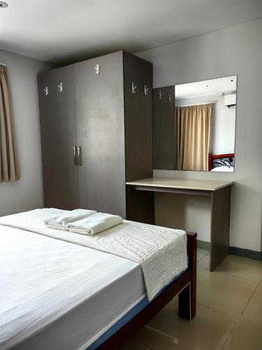 a bedroom with a bed with a mirror and cabinets at Pacific FairPrice Private room in Nadi