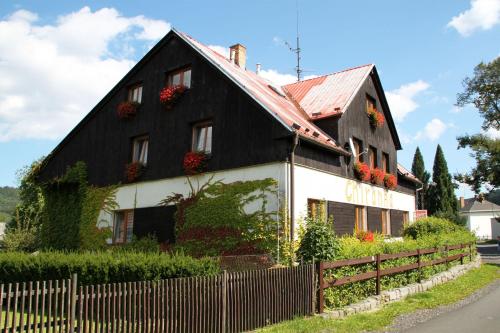 a black and white house with flowers on it at Chalupa Chiranka in Lipova Lazne
