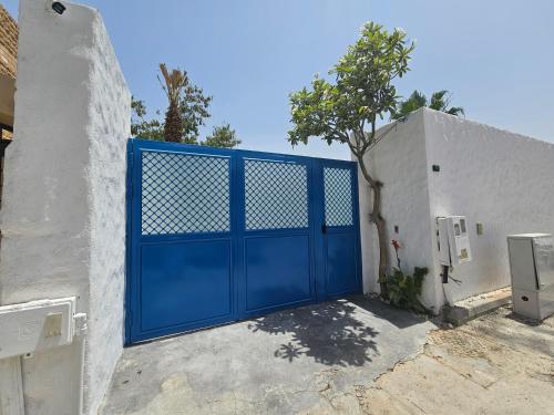 a blue garage door on a white building at شاليهات كريستال فيوز in Quai