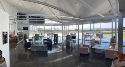 a lobby with chairs and tables and glass walls at White Sands Estate in Falmouth