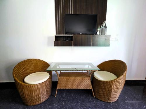 a table with two chairs and a tv in a room at Lemon Grass Resort & Spa in Havelock Island