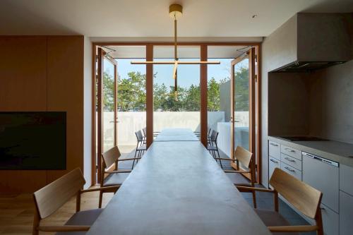 a long dining room with a long table and chairs at Villa NIGIN in Miyazu