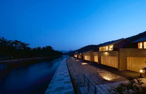 a building next to a river at night at Villa NIGIN in Miyazu