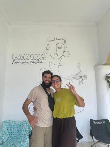 two men posing for a picture in front of a wall at Lanina homestay in Ipi