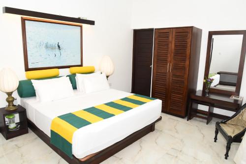 a bedroom with a bed and a desk and a television at Huluganga Ridge, Kandy in Kandy