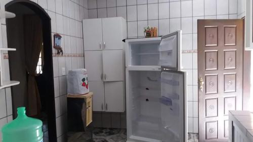 een keuken met een koelkast en witte kasten bij Sítio em Barra de Jacuípe in Camaçari
