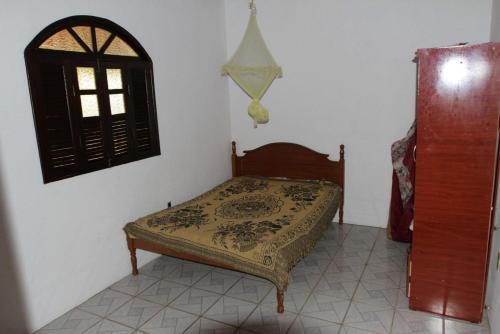 een klein bed in een kamer met een raam bij Sítio em Barra de Jacuípe in Camaçari
