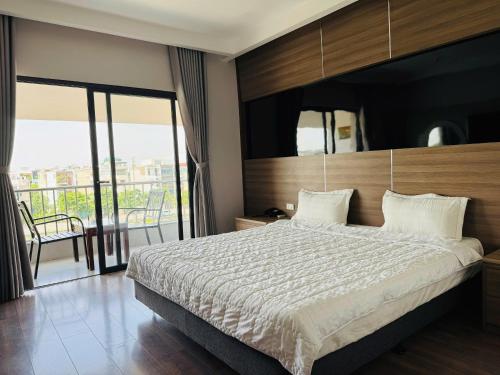 a bedroom with a large bed and a balcony at Khách Sạn Sông Lô in Hải Dương
