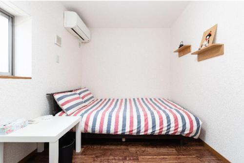 a small room with a bed and a table at 花迹民宿一号馆201 通天阁天王寺步行圈 心斋桥日本桥4分钟车程 in Osaka