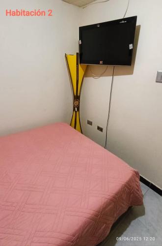 a room with a bed and a flat screen tv at Acogedor Apartamento en zona turistica de Popayán in Popayan