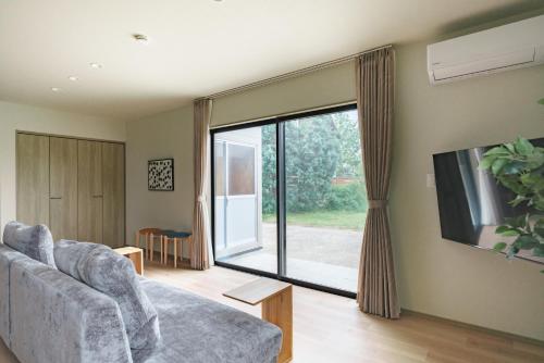 a living room with a couch and a large window at Green Peak 1 in Aso