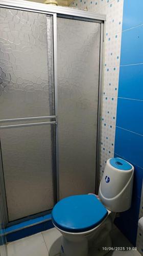 a bathroom with a shower and a toilet with a blue seat at Acogedor Apartamento en zona turistica de Popayán in Popayan