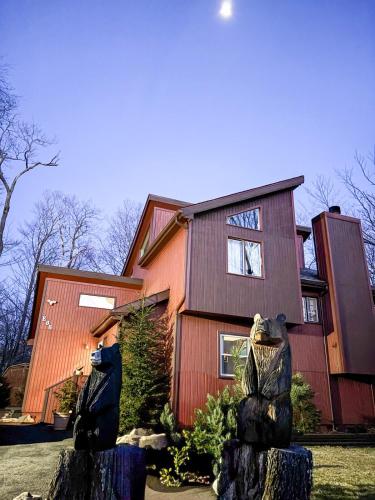 a house with a bear statue in front of it at Bool Bear Lodge a pet friendly Pocono Vacation Home in Tobyhanna