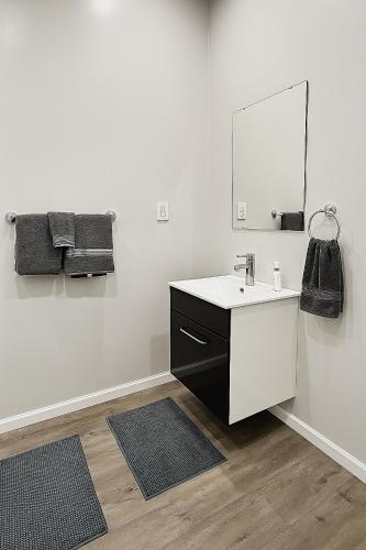 a white bathroom with a sink and a mirror at Suite 3 Eighteen in Shelbyville