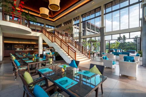 Un restaurante con mesas y sillas y una escalera. en Laguna Parkside Lăng Cô, en Lang Co